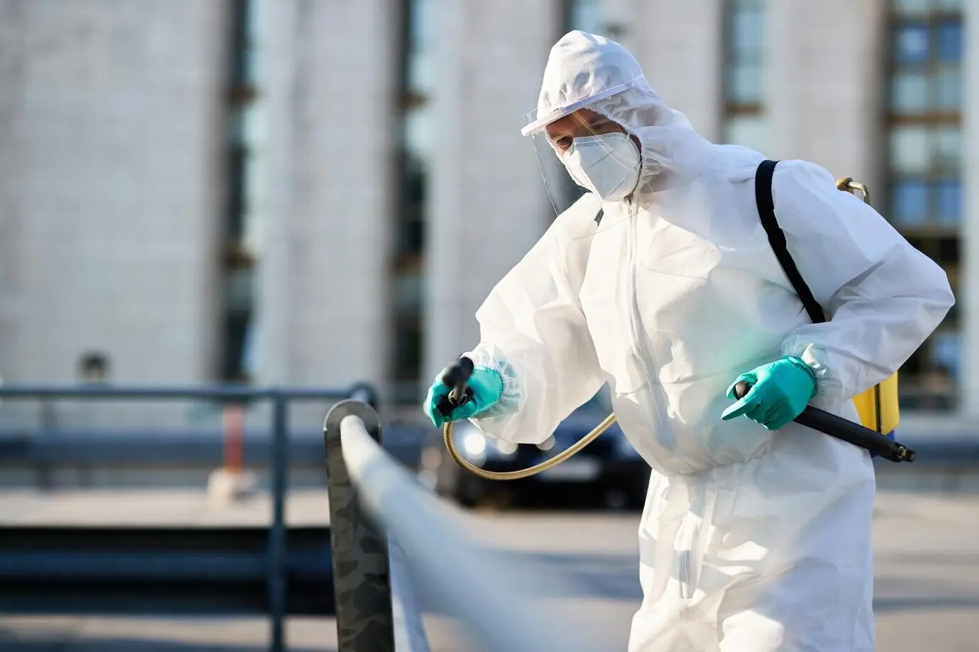 Сотрудник по дезинфекции очищает городские улицы во время пандемии COVID‑19.